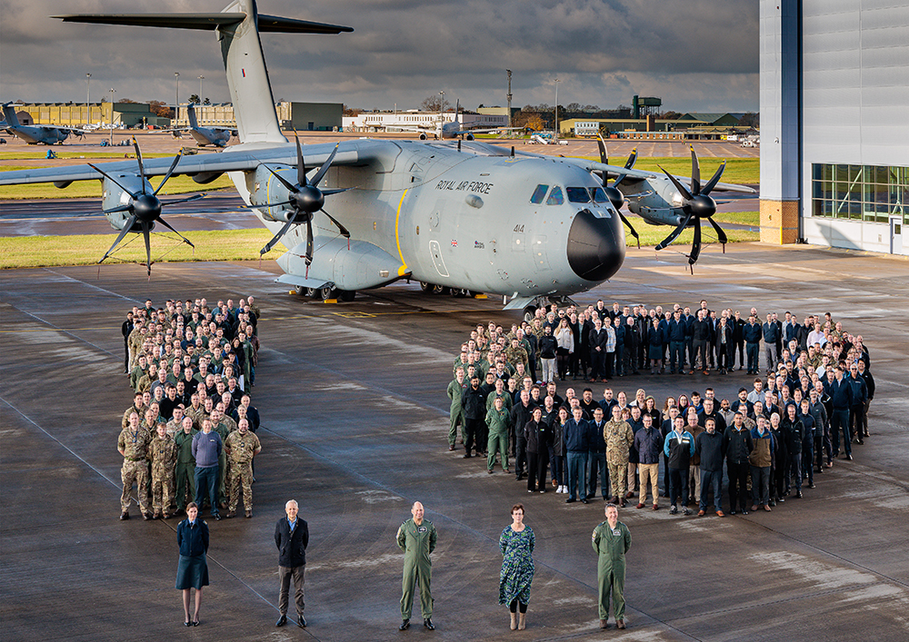 Photo: Air Mobility Force personnel formed as the figure 10 in front of an Atlas C Mk.1 aircraft. Image is taken from height